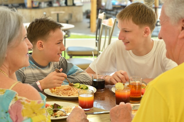 Großeltern mit Enkeln beim Frühstück im tropischen Resort