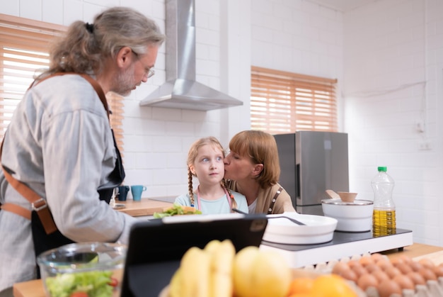 Großeltern mit Enkeln und Kindern versammeln sich in der Küche, um das Abendessen für den Tag zuzubereiten