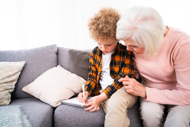 Großeltern und Enkel spielen zu Hause - Familie zu Hause, Großmutter kümmert sich um Neffen