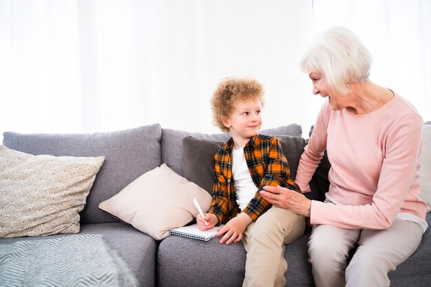 Großeltern und Enkel spielen zu Hause - Familie zu Hause, Großmutter kümmert sich um Neffen