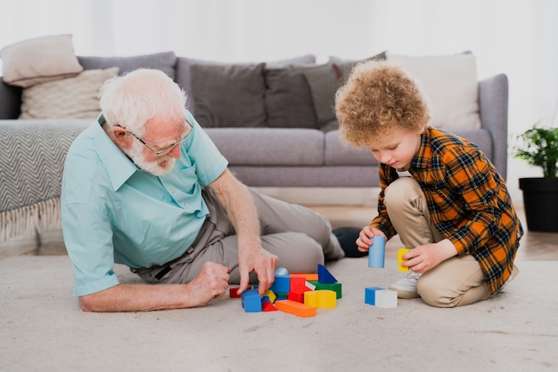 Großeltern und Enkel spielen zu Hause - Familie zu Hause, Großvater kümmert sich um Neffen