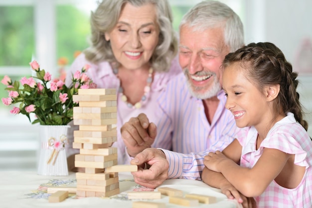 Großeltern und Enkelin spielen mit Holzklötzen