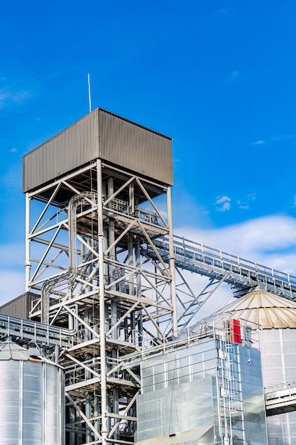 Großer Bauturm in großer Fabrik. Metallischer Turm am blauen Himmel. Großes Lager.