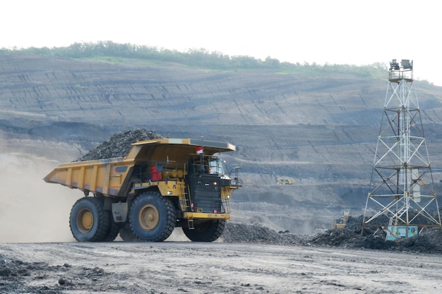 Großer gelber Lastwagen, der Kohle aus dem Steinbruch der Kohlebergbauindustrie transportiert