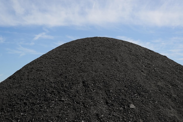 Großer Haufen Steinkohle gegen den blauen Himmel im Freien