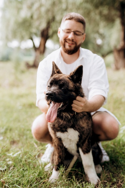 Großer Hund für einen Spaziergang mit einem Kerl und einem Mädchen auf der grünen Prärie