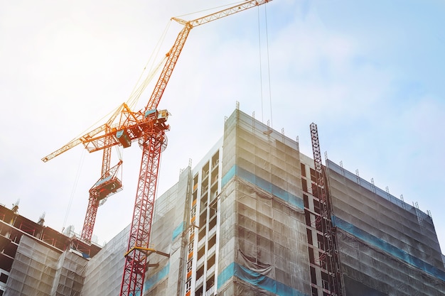 Foto großer kran und hochbau-baustelle mit blauem himmel.