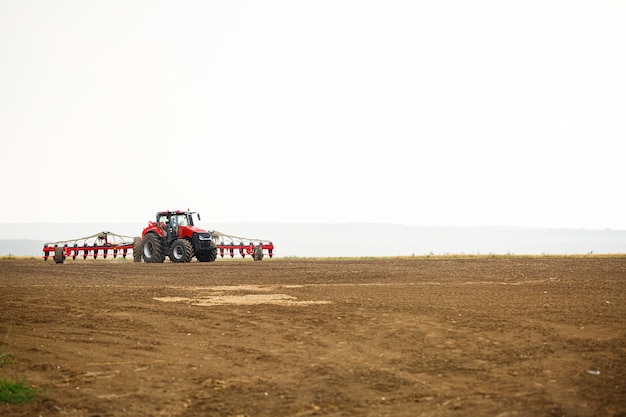 Großer moderner Traktor zur Vorbereitung des Feldes nach dem Winter für die Aussaat von Getreide