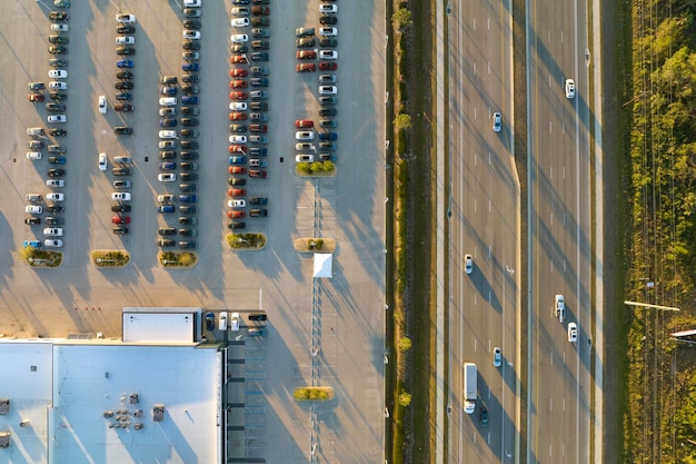 Großer Parkplatz eines lokalen Händlers mit vielen brandneuen Autos, die auf der Autobahn zum Verkauf geparkt sind