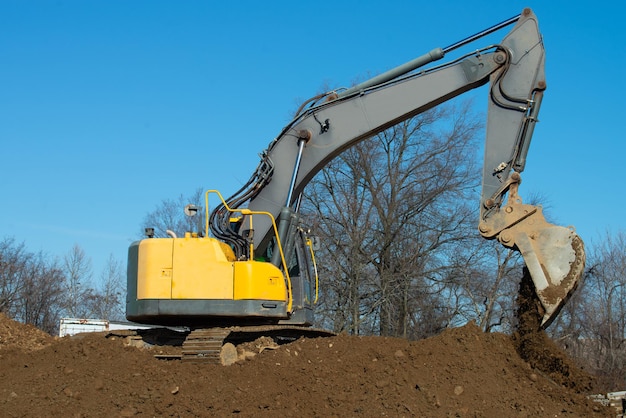 Großer Raupenbagger gießt einen Haufen Sand