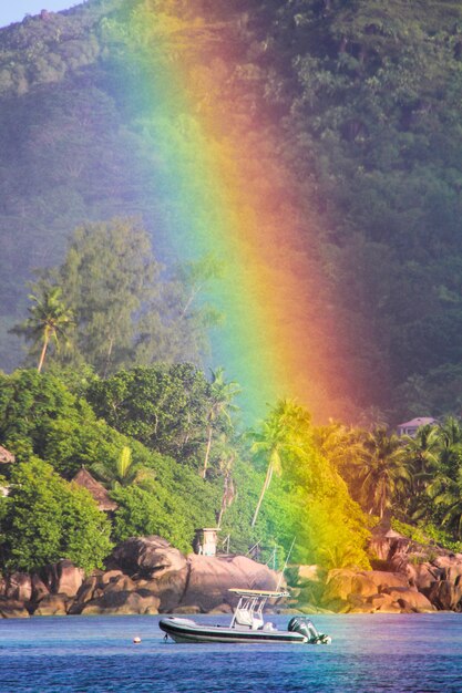 Großer Regenbogen über tropischer Insel und luxuriösem Hotel