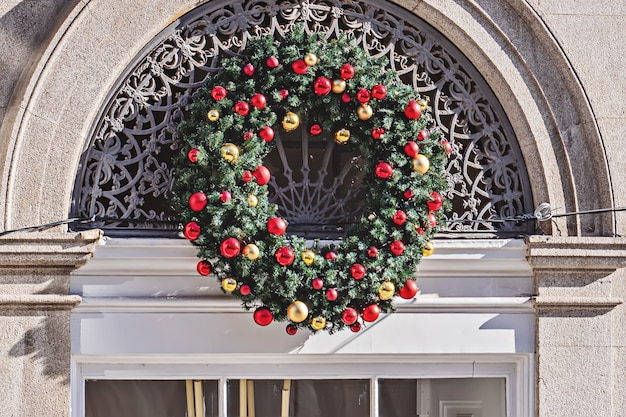 Großer Weihnachtskranz schmückt das Gebäude draußen am Weihnachtswochenende, Frontalansicht