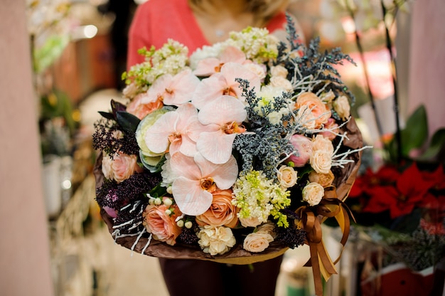 Großer Winterblumenstrauß von bunten Blumen in den Frauenhänden