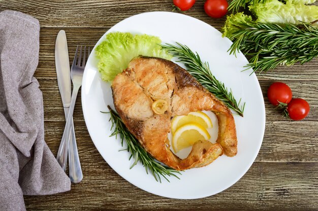 Großes geröstetes Karpfensteak mit Zitrone und Rosmarin. Draufsicht.