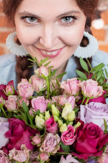 Großes Gesicht eines schönen Mädchens mit einem Blumenstrauß Augen einer glücklichen Frau mit Blumen