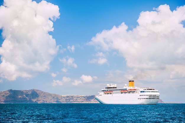 Großes Kreuzfahrtschiff am Meer in der Nähe der Inseln. Santorin, Griechenland. Schöne Landschaft mit Meerblick.