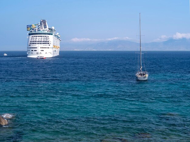 Foto großes kreuzfahrtschiff und yacht im seehafen der insel mykonos in griechenland