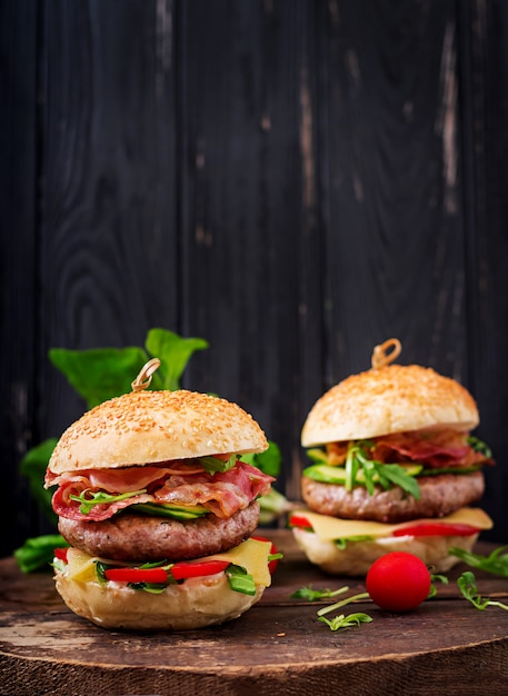 Großes Sandwich - Hamburgerburger mit Rindfleisch, Käse, Tomate, Gurke und gebratenem Speck.