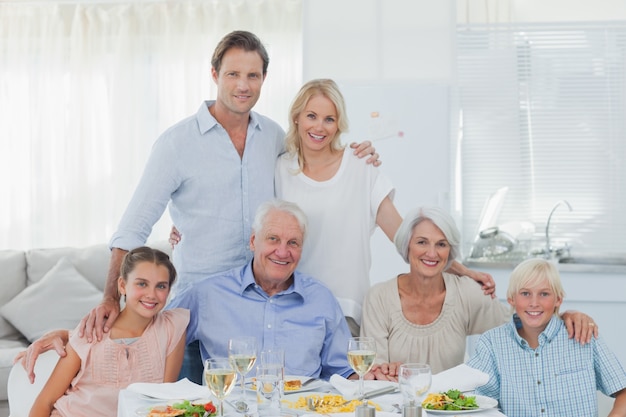 Großfamilie, die am Abendtische lächelt