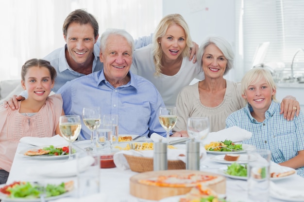 Großfamilie, die an der Abendessenfamilie lächelt