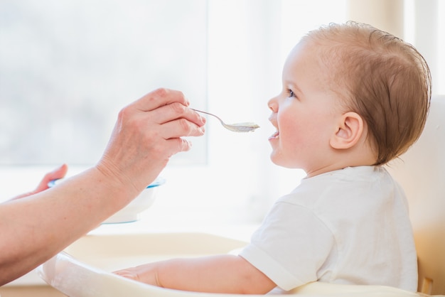 Großmutter gibt Babynahrung von einem Löffel