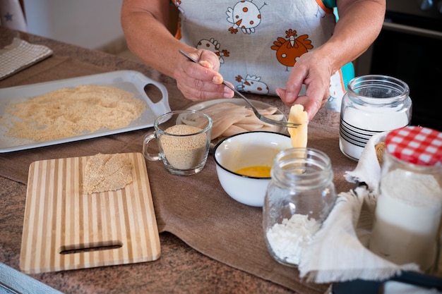 Großmutter kocht zu Hause Fisch - drinnen in der Küche - Rentner - Arme und Hände auf dem Foto