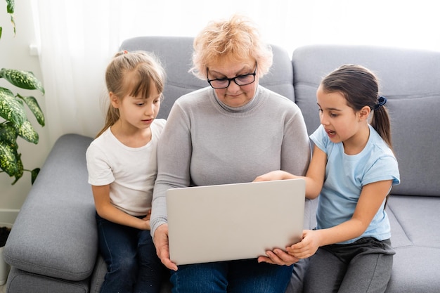 Großmutter mit Enkelinnen benutzen einen Computer.