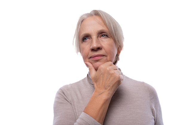 Großmutter mit grauen Haaren denkt auf einem weißen Hintergrund