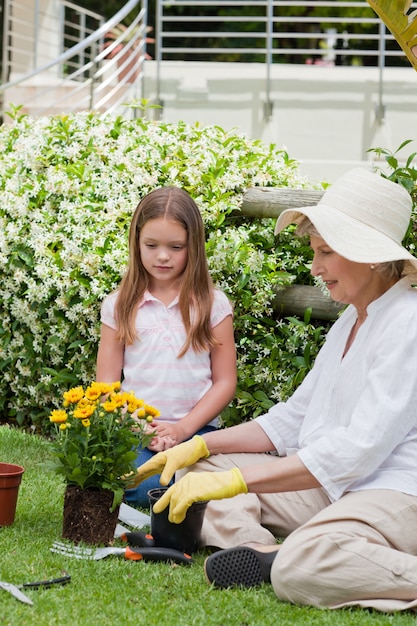 Großmutter mit ihrer Enkelin, die im Garten arbeitet