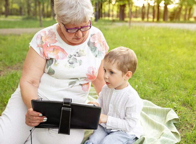 Großmutter und enkel mit tablette. genießen sie die freizeit mit der familie