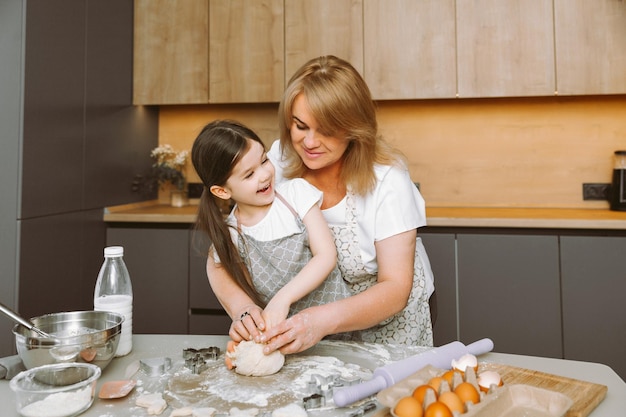 Großmutter und Enkelin der glücklichen Familie kochen in der Küche den Teig und backen Osterkuchen für Ostern