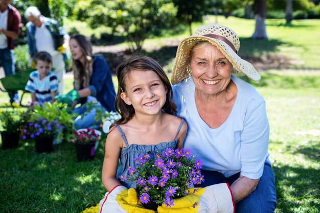 Großmutter und Enkelin, die einen Blumentopf bei der Gartenarbeit halten