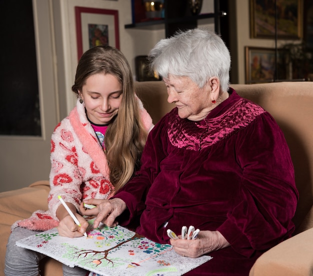 Großmutter und Enkelin malen zum Spaß zu Hause