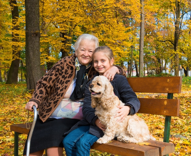 Großmutter und Kind sitzen auf der Bank im Herbstpark