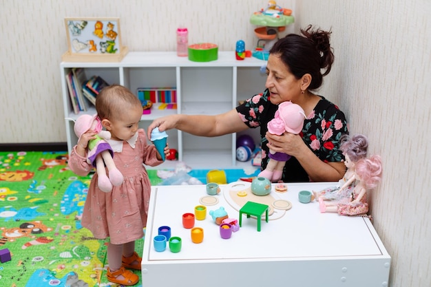 Großmutter und Kleinkind spielen zu Hause mit Spielzeug