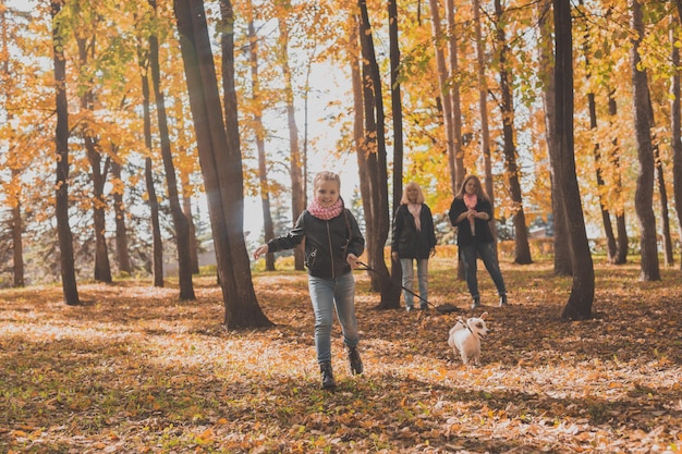 Großmutter und Mutter mit Enkelin gehen zusammen im Herbstpark und haben Spaß bei der Generation