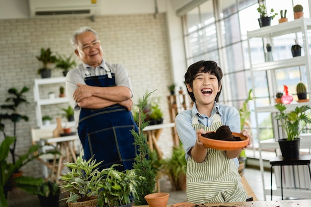 Großvater Gartenarbeit und Unterricht Enkel kümmern sich um Pflanze