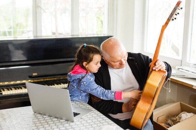 Großvater lehrt Mädchen glücklich Klavier spielen