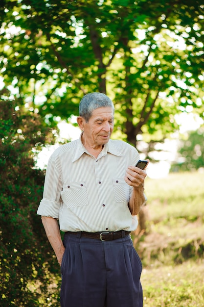 Großvater mit Handy in der Hand.