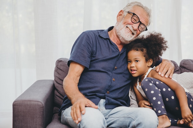 Großvater umarmt die Umarmungsliebe für die kleine Nichte in einem warmen Familienheim.