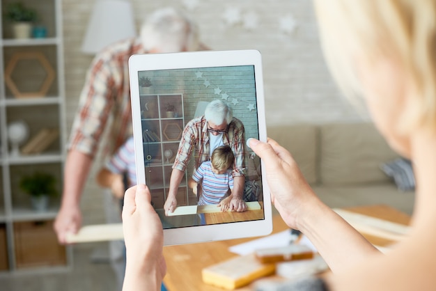 Großvater und Enkel auf dem Bildschirm des digitalen Tablets