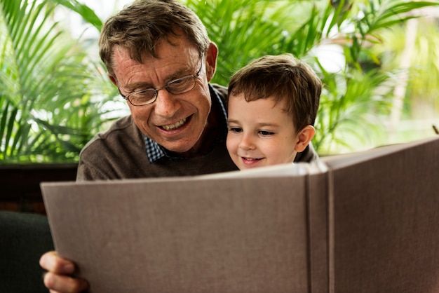 Foto großvater und enkel, die zusammen ein buch lesen