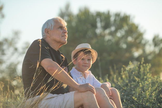 Großvater und Enkel genießen es, draußen zu lächeln und sich zu umarmen. Konzept einer freundlichen Familie