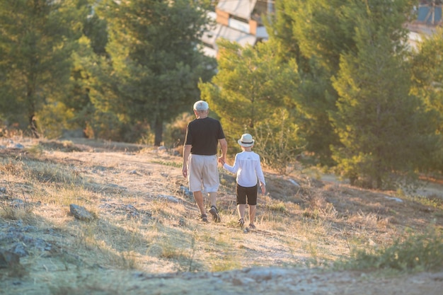 Großvater und Enkel genießen es, draußen zu lächeln und sich zu umarmen. Konzept einer freundlichen Familie