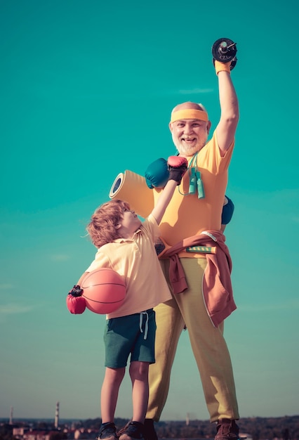 Foto großvater und enkel mit basketballball und yogamatte in den händen, vater und sohn beim training