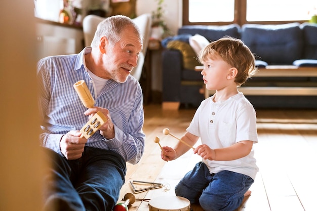 Großvater und Enkel spielen zu Hause Musik
