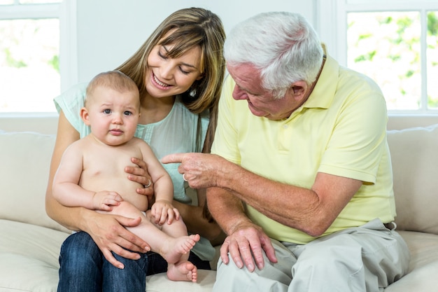 Großvater und Mutter mit Baby auf Sofa