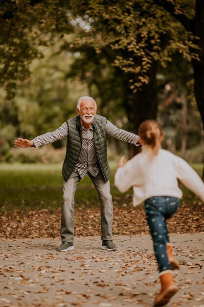 Großvater verbringt am Herbsttag Zeit mit seiner Enkelin im Park