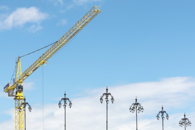 Grúa amarilla contra el cielo y faroles.