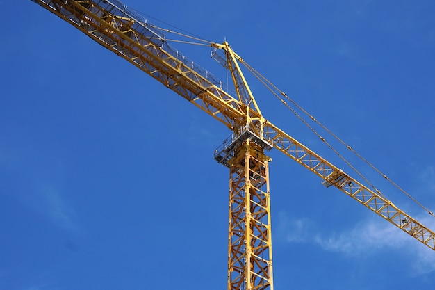 Grúa de construcción amarilla contra el cielo azul